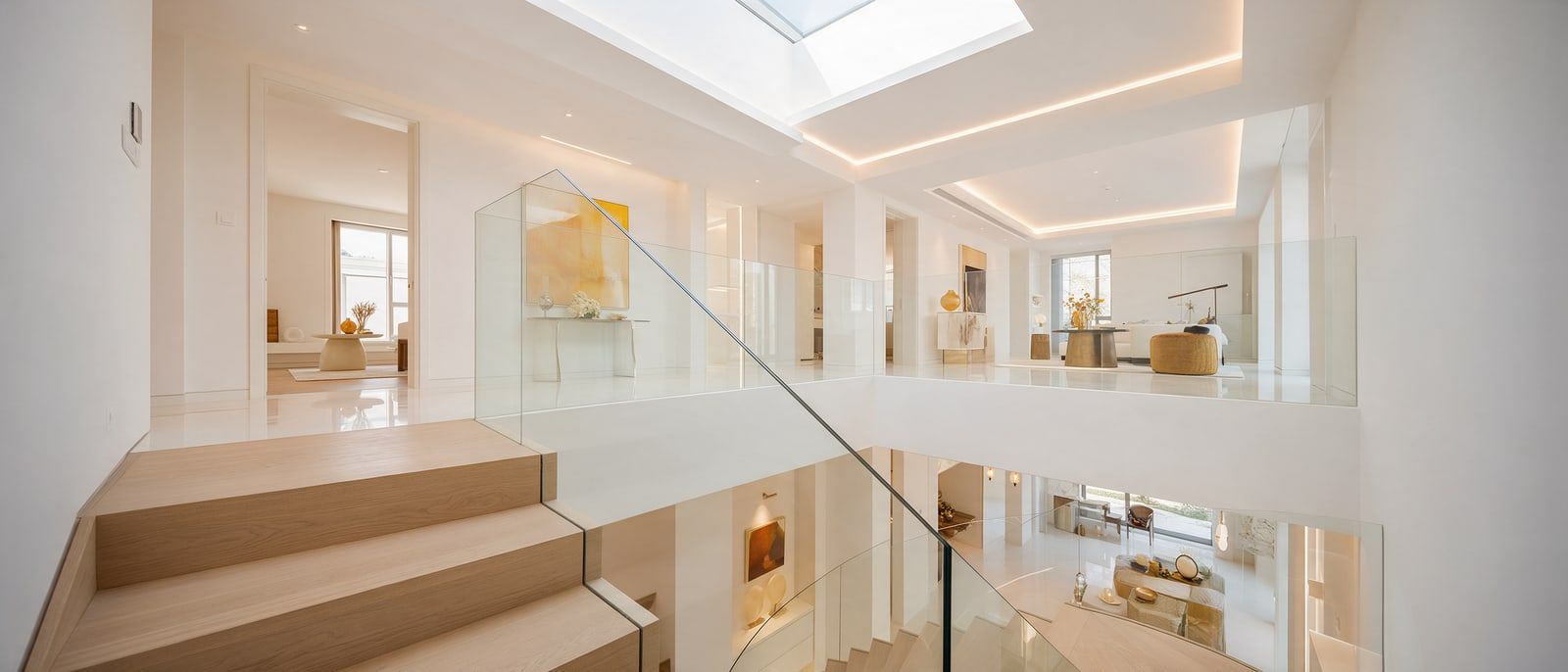 Treppe mit rahmenlosem Glasgeländer in einem hellen Haus